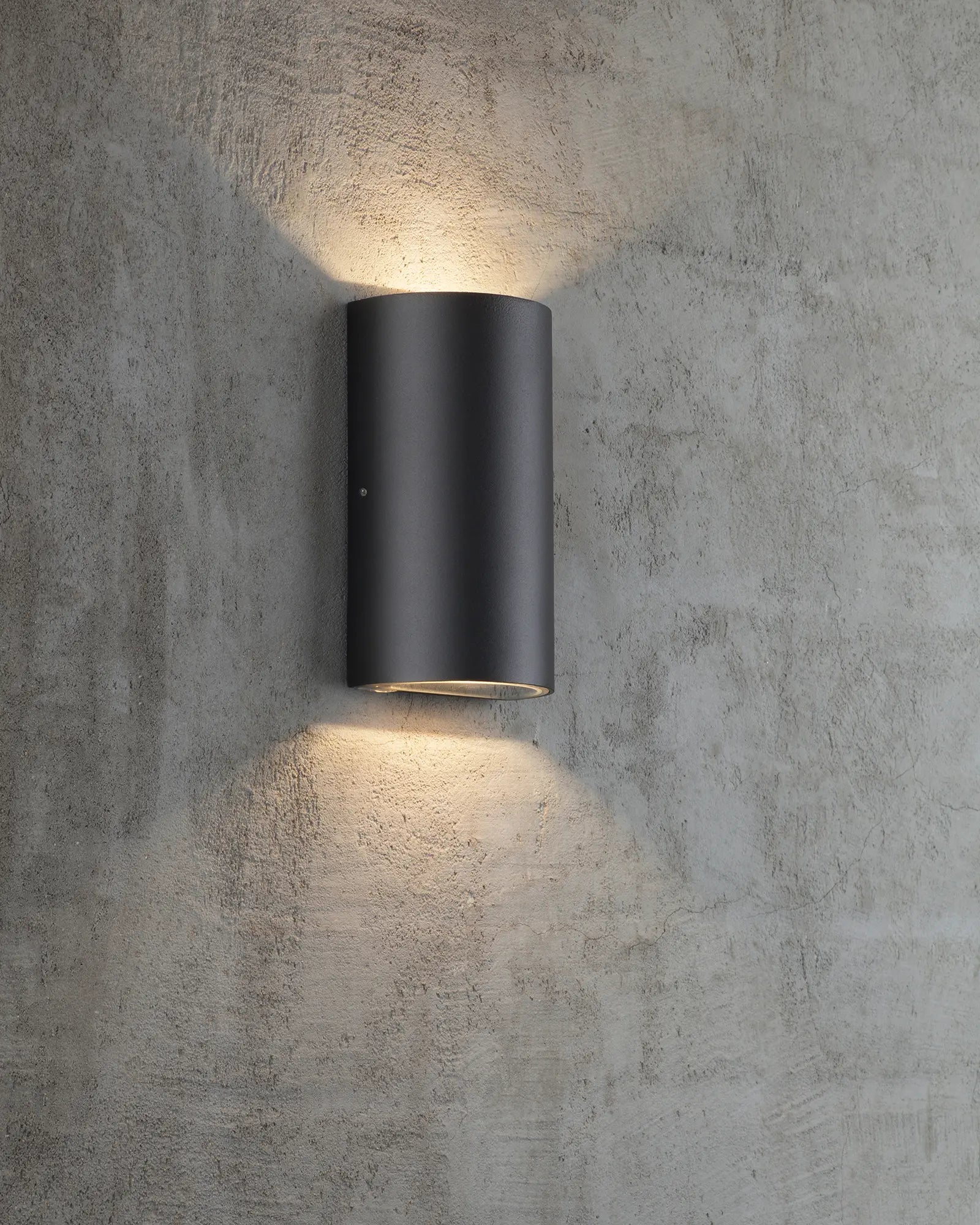 Rold minimal scandinavian half cylinder outdoor wall light in black on concrete wall