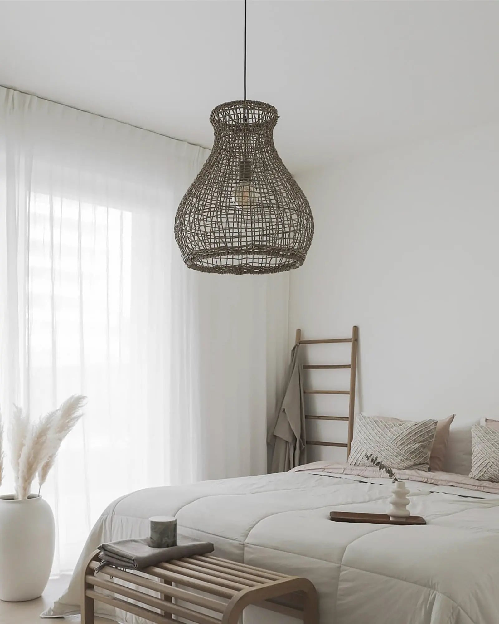 Seagrass organic pendant light above a bed