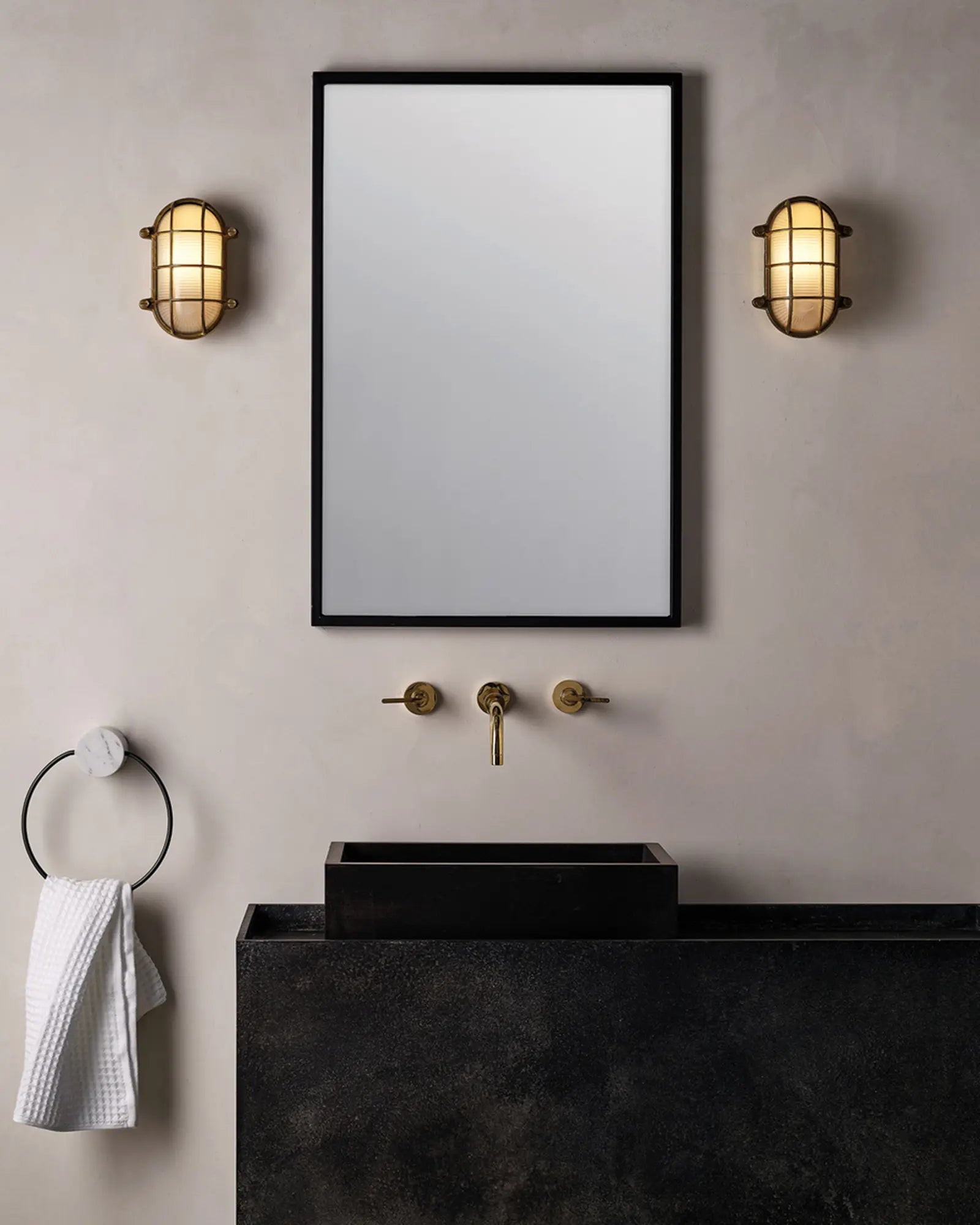 Thurso oval brass and glass classic wall light on the mirror's sides in a bathroom