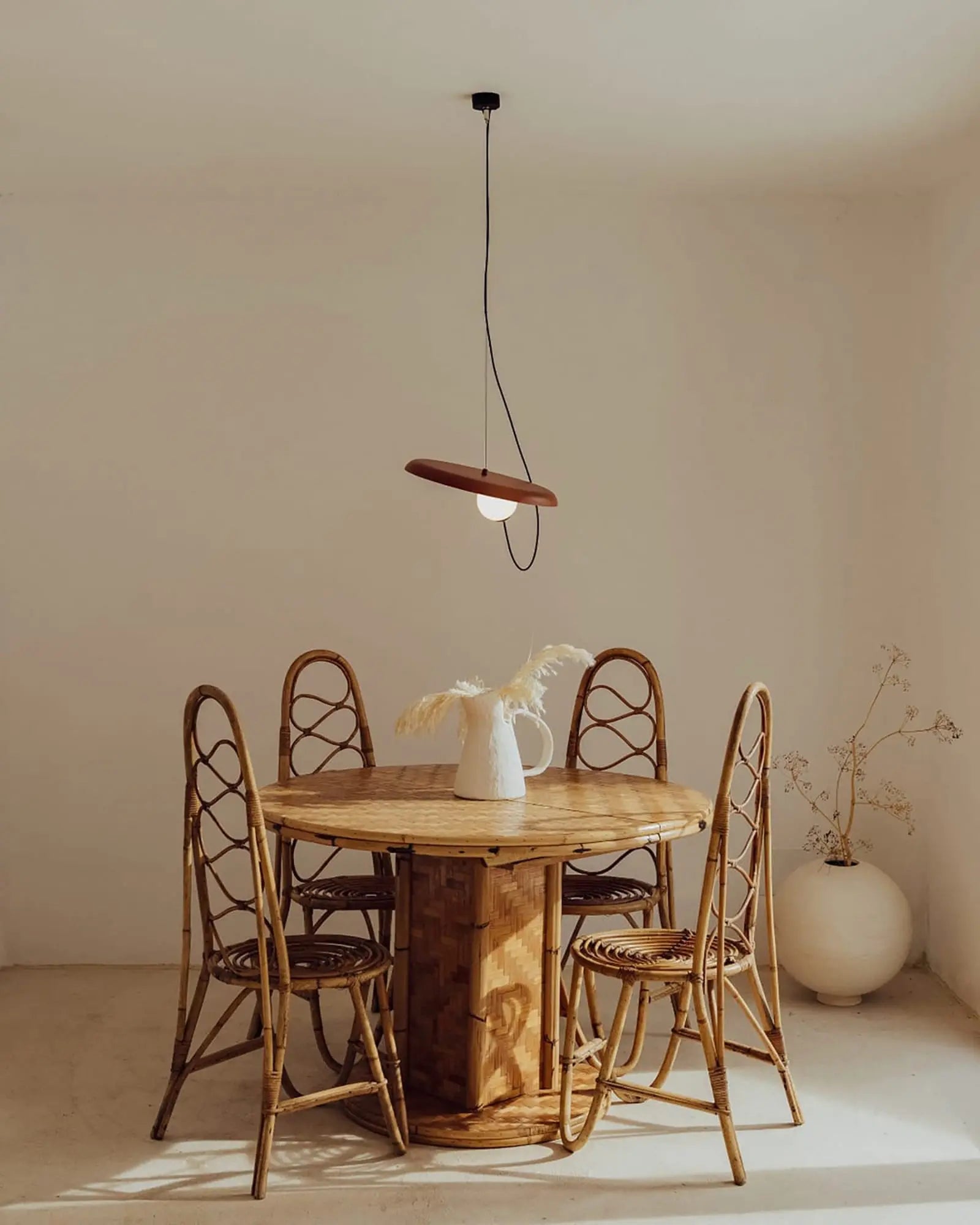 Wire pendant light above a round dining table